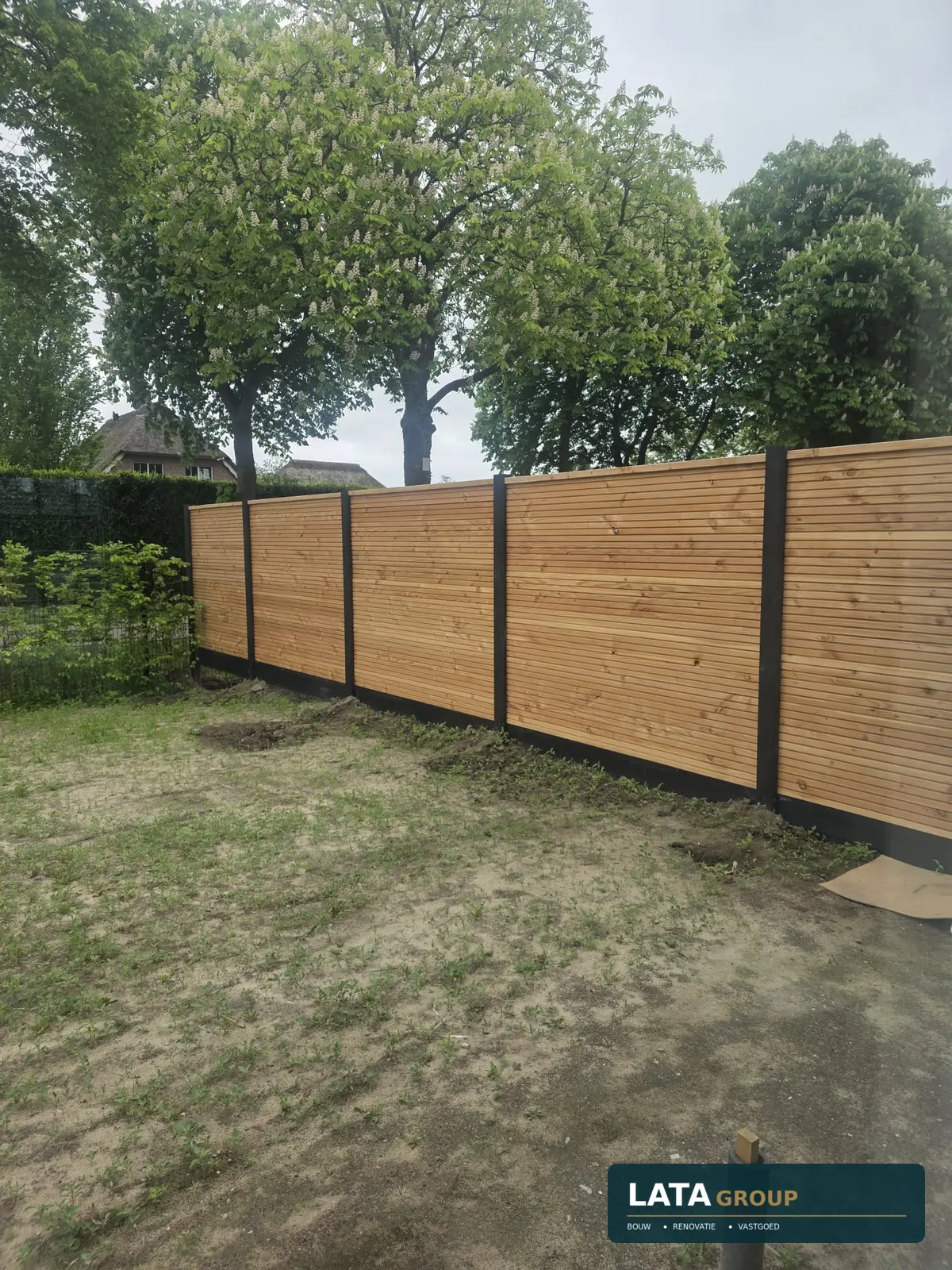 Door LATA geplaatste houten erfafscheiding met donkere staanders